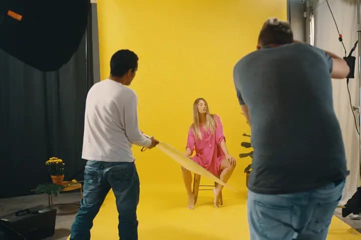 The photographer leans in; the model holds the pose.