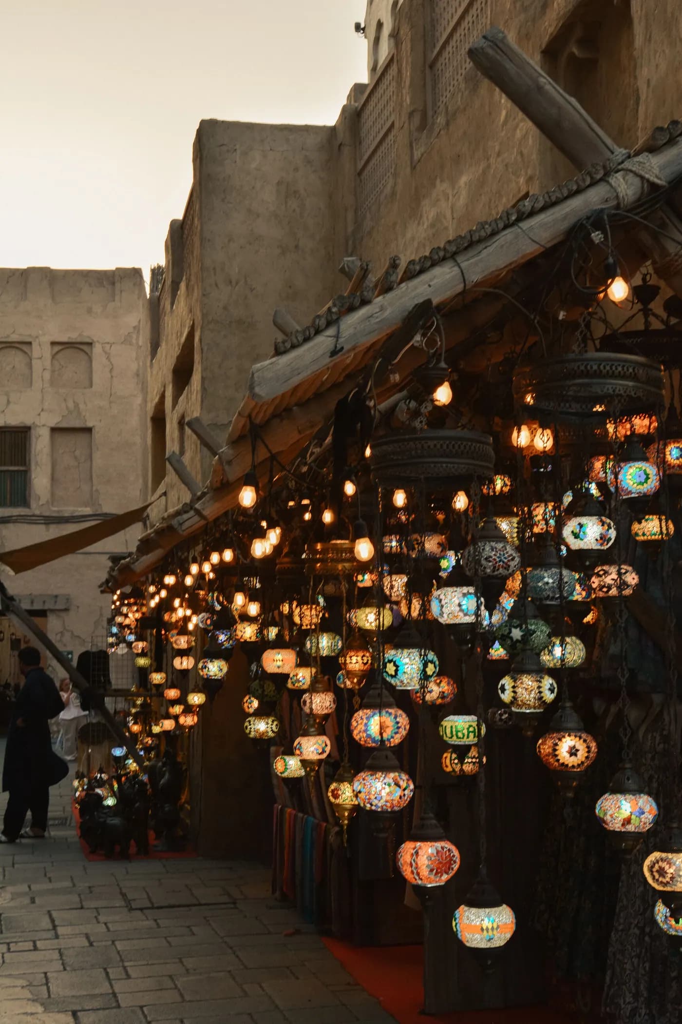 Lanterns hanging in a covered souk at dusk.